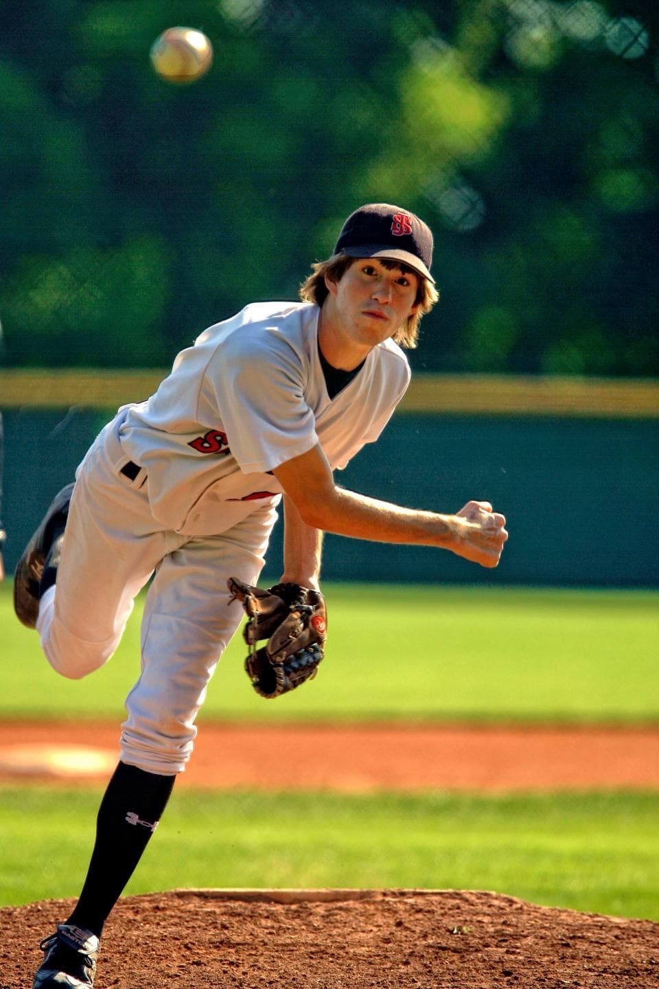 A young pitcher follows through on a pitch from the mound
